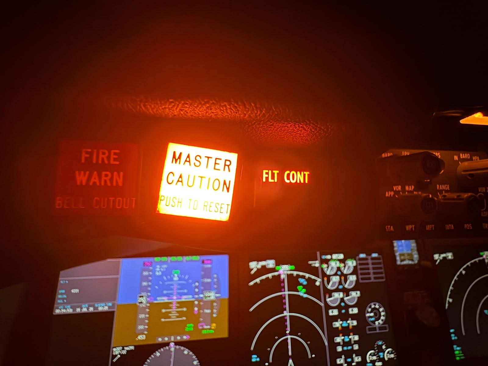 Luz MASTER CAUTION acesa no painel do cockpit, ao lado dos avisos FIRE WARN e FLT CONT